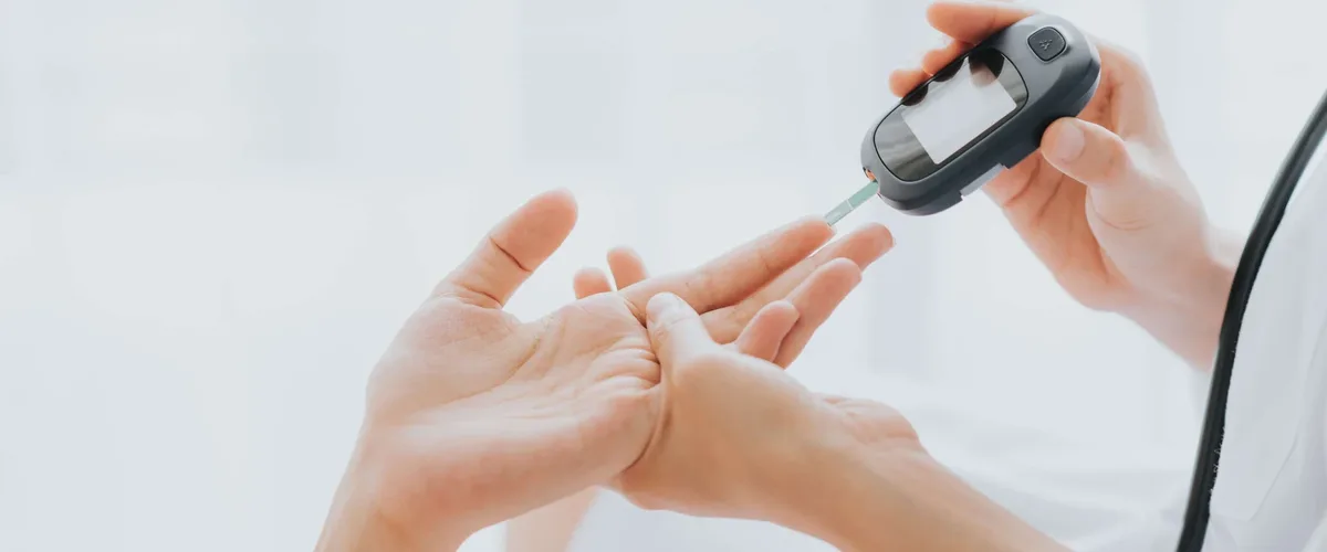 Finger-prick blood glucose test with a test strip in a handheld glucose meter